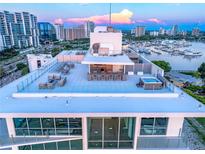 A luxurious rooftop terrace features a bar, seating, and a hot tub overlooking the city skyline at 111 Golden Gate Pt # 602, Sarasota, FL 34236