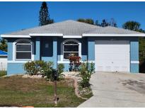 Blue house with a white garage door and landscaping at 1308 72Nd E St, Palmetto, FL 34221