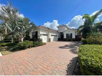 Beautiful single-Gathering home with a three-car garage, brick driveway, and manicured landscaping at 15618 Castle Park Ter, Lakewood Ranch, FL 34202