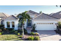 White one-story home with tile roof, two-car garage, and landscaped yard at 7060 Whitemarsh Cir, Lakewood Ranch, FL 34202