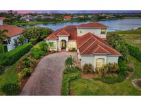 Luxury home with lake views and a brick driveway at 1509 Raphis Royale Blvd, Englewood, FL 34223