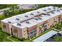 An aerial view of a well-maintained condominium building with lush landscaping and parking at 1540 Glen Oaks E Dr # B336, Sarasota, FL 34232