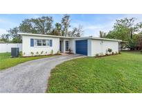 Charming Ranch home with a blue garage door and landscaped yard at 4643 Brooksdale Dr, Sarasota, FL 34232