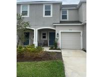 Two-story townhome with a gray exterior and a two-car garage at 8560 Lunar Skye St, Sarasota, FL 34241