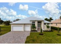 Two-story house with light beige walls, white garage doors, and a paved driveway at 16381 Cape Horn Blvd, Punta Gorda, FL 33955
