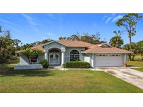 Single-story home with two-car garage, mature landscaping and driveway at 2977 Begonia Ter, North Port, FL 34286