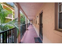 Hallway features a peach-colored corridor with exterior views and a welcome mat, leading to residences at 3700 S Osprey Ave # 214, Sarasota, FL 34239