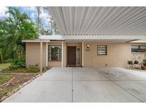 Tan house exterior with carport and lush landscaping at 4773 Village Gardens Dr # 97, Sarasota, FL 34234