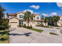 Attractive townhome complex featuring well-manicured lawns, mature palm trees, and tile roofs at 8256 Enclave Way # 101, Sarasota, FL 34243