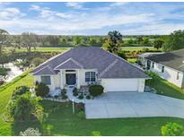 Single-story home with landscaped yard and a two car garage at 1057 Meadow Breeze Ln, Sarasota, FL 34240