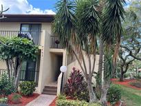Exterior view of condo building with lush landscaping and walkway at 6447 Egret Ln # 413, Bradenton, FL 34210