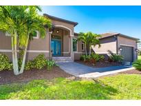 Single-Gathering home with palm trees, walkway, and attached garage at 85 Spaniards Rd, Placida, FL 33946