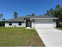 Charming single-story home with a two car garage, well maintained lawn, and a gray roof at 3006 Chickasaw Ave, North Port, FL 34288
