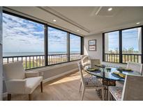 Bright dining area with glass table and ocean view at 5740 Midnight Pass Rd # 506F, Sarasota, FL 34242