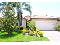 Charming home with a well-manicured front yard, lush landscaping, and a brick driveway at 135 Ventosa Pl, Nokomis, FL 34275
