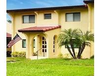 Tan building exterior with red tile roof, lush landscaping, and American flag at 1446 56Th W St # 1446, Bradenton, FL 34209
