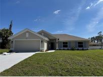 Charming single-story home featuring a two-car garage, well-manicured lawn, and blue shutters at 4744 Badali Rd, North Port, FL 34286