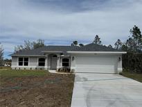 Charming one-story home with a two-car garage and a well-manicured lawn, complemented by a neatly paved driveway at 5496 Azalea St, North Port, FL 34291