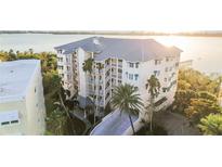 Three-story waterfront building with balconies and palm trees at 242 Hidden Bay Dr # 403, Osprey, FL 34229