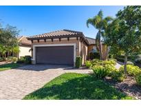 Single-story home with brown garage door, landscaping, and brick paver driveway at 4713 Stafford Ct, Palmetto, FL 34221