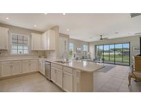 Modern kitchen with white cabinets, stainless steel appliances, and breakfast bar at 5431 Taliaferro Ct, Palmetto, FL 34221
