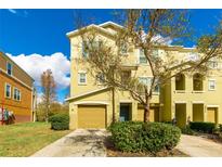 Three-story townhome with tan siding and a two-car garage at 9016 White Sage Loop, Lakewood Ranch, FL 34202