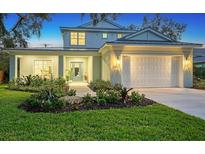Two-story home with a white exterior, landscaping, and a two-car garage at 2492 S Milmar Dr, Sarasota, FL 34237