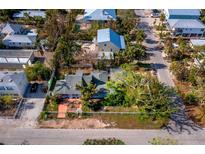 Coastal cottage with mature trees and a fenced yard at 6901 Poinsettia Ave, Longboat Key, FL 34228