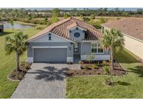 Single-story home with gray exterior, tile roof, and landscaped yard at 225 Daylily Blvd, Nokomis, FL 34275