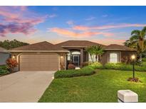 Beautiful home exterior at dusk with landscaping at 6223 90Th Avenue E Cir, Parrish, FL 34219