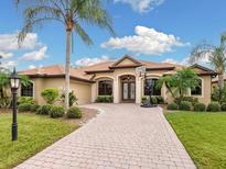 Tan one-story house with tile roof, double door entry, and a basketball hoop at 7659 Trillium Blvd, Sarasota, FL 34241