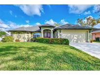 One-story home with a well-manicured lawn and two-car garage at 17040 Kellog Ave, Port Charlotte, FL 33954
