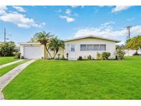 Charming ranch house with a well-manicured lawn and attached garage at 2057 Garden Pkwy, Bradenton, FL 34205