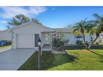 White single story home with green accents, attached garage, and landscaped lawn at 4206 Chinaberry Rd, Bradenton, FL 34208