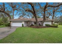 One-story house with white exterior and large oak trees at 5502 Garden Lakes Oak, Bradenton, FL 34203
