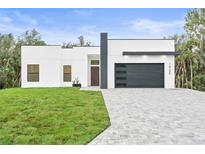 Modern house exterior with gray paver driveway at 14135 Carrie Ave, Port Charlotte, FL 33953