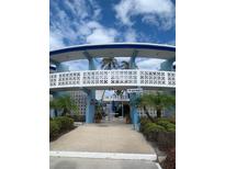 The Dorset: Exterior view of building, showing walkway, landscaping, and unique architectural details at 475 Benjamin Franklin Dr # 202, Sarasota, FL 34236