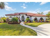 White house with red tile roof, landscaping, and a paved driveway at 5156 Little Brook Ct, Sarasota, FL 34238