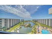 Aerial view of waterfront community with pool, lush landscaping, and ocean access at 5770 Midnight Pass Rd # 705C, Sarasota, FL 34242