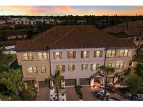 Three-story townhome with Spanish tile roof, three-car garage, and lush landscaping at 1904 Monte Carlo Dr, Sarasota, FL 34231