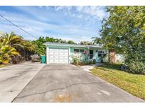 Light teal home with a white garage door and landscaped yard at 312 San Marie Dr, Punta Gorda, FL 33950