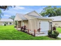 Tan one-story house with attached garage and landscaping at 4844 Alamo Ct, New Port Richey, FL 34655