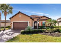 Beautiful craftsman style home with a brown garage door and lush landscaping at 5238 Napoli Run, Bradenton, FL 34211