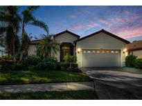 Inviting single-story home with a two-car garage and lush landscaping at 8231 Stirling Falls Cir, Sarasota, FL 34243