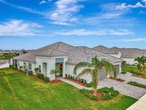 Single-story home with tile roof, landscaped yard, and two-car garage at 12496 Palatka Dr, Venice, FL 34293