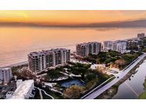 Aerial view of luxurious beachfront condos with tennis courts and ocean views at 415 L Ambiance Dr # C403, Longboat Key, FL 34228