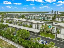 Aerial view of waterfront community with pool, parking, and boat slips at 4360 Chatham Dr # 108, Longboat Key, FL 34228