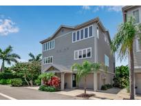 Three-story house with gray siding, attached garage, and palm trees at 528 Forest Way, Longboat Key, FL 34228