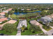 Aerial view of a single-Gathering home in a golf course community with a lake at 12240 Thornhill Ct, Lakewood Ranch, FL 34202