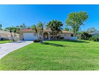 Charming home with a well-manicured lawn and tropical landscaping at 220 Monet Dr, Nokomis, FL 34275